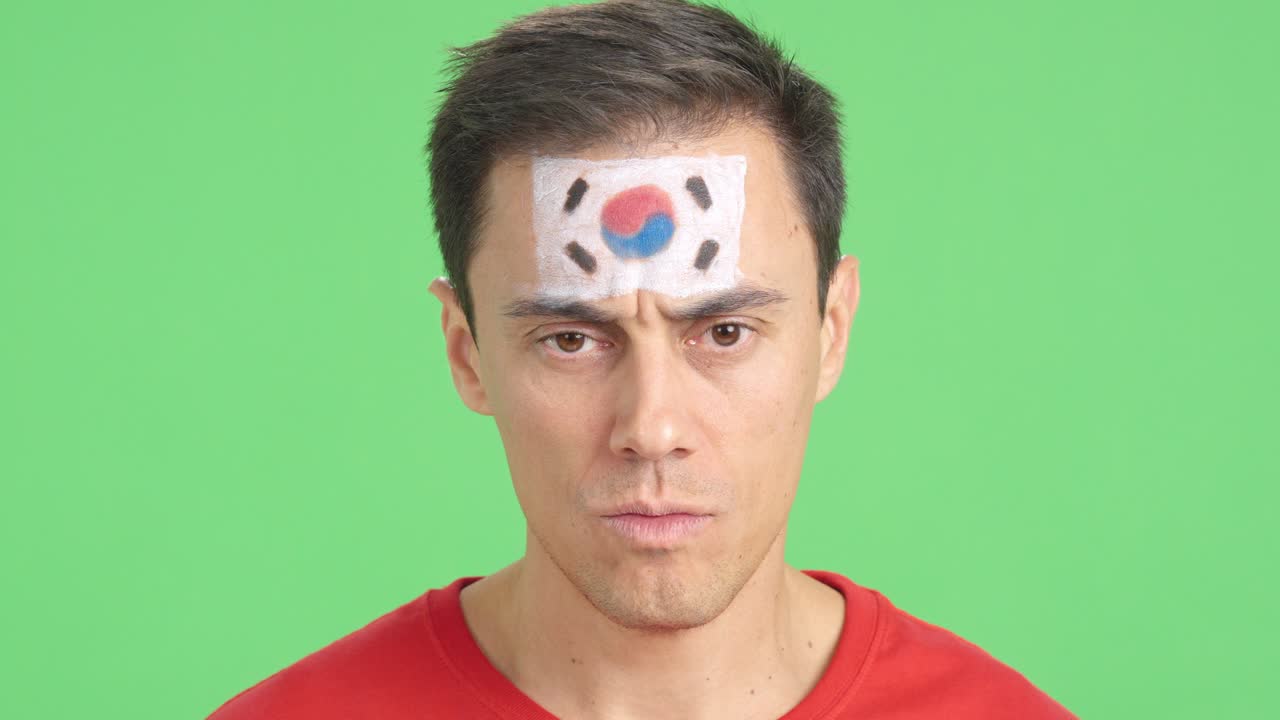 Serious man with a south korean flag painted on the face