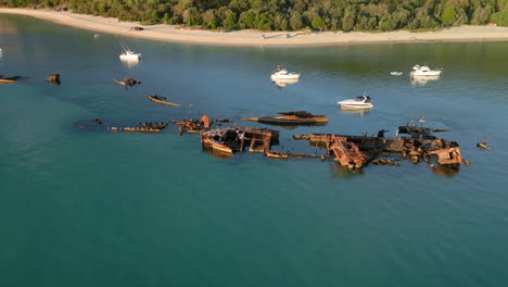 viejo barco oxidado, naufragio drone vista de cerca, zoom en artefacto en descomposición flotando en la isla de tangalooma moreton, costa de playa de arena blanca