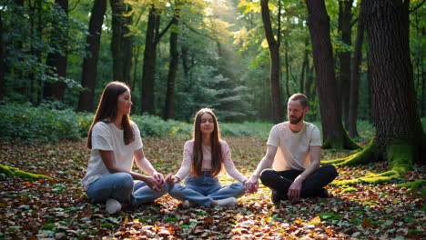 family meditating in a forest