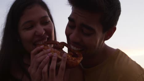 Young-couple-eating-together-from-food-truck