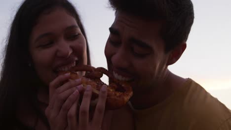 una joven pareja comiendo juntos en un camión de comida