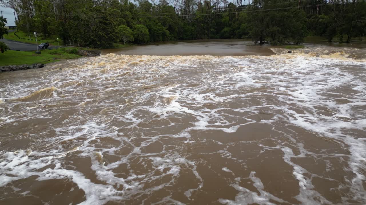 Coomera, Gold Coast, 2 January 2024 - Aerial view of turbulent waters at the Coomera River Causeway under flood waters from the 2024 Storms in January