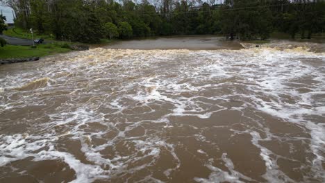 coomera, gold coast, 2 de enero de 2024 - vista aérea de aguas turbulentas en la calzada del río coomera bajo aguas de inundación de las tormentas de 2024 en enero