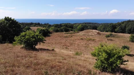 Aerial-view-of-the-coastline-of-Sejerøbugten-with-hills,-fields-and-ocean