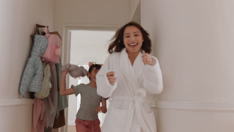 una niña asiática feliz jugando a la pelota con su madre corriendo por la casa disfrutando de una divertida mañana de fin de semana con su hijo 4k