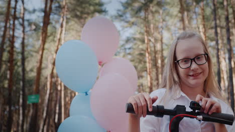 portrait d'une fille gaie à la barre d'un scooter et de ballons