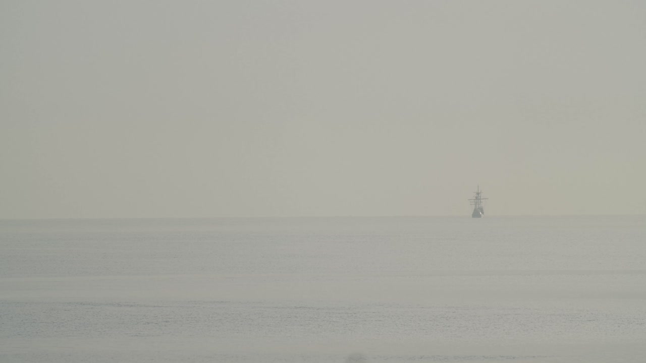 페르디난드 마젤란 나오 빅토리아 카락 보트 복제품은 일출 시 지중해에서 멀리 항해하며 새는 60fps의 느린 동작으로 잔잔한 바다에서 날아갑니다.