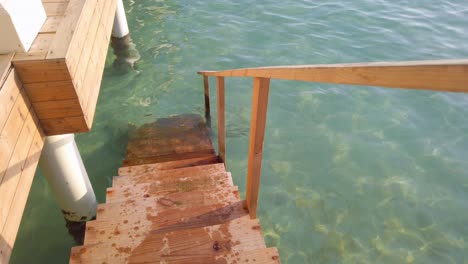 wooden staircase of ocean villa leading down into water