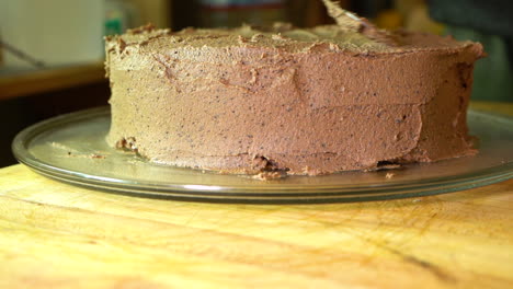 Frosting-a-delicious-homemade-gluten-free-two-layer-chocolate-cake,-Slow-motion