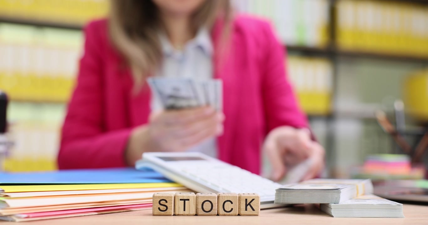 Word stock from cubes against woman counting dollars