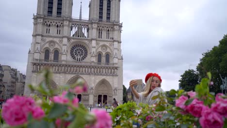 young woman taking selfie in paris at city notre dame using mobile phone