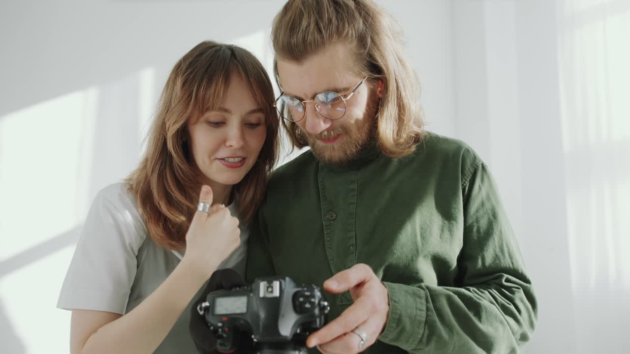 Cheerful Woman and Photographer Checking Photos and Talking in Studio