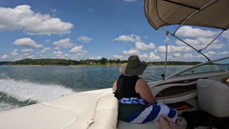 slow motion of woman enjoying the scenery from the cockpit of sports boat while cruising on table rock lake on a sunny afternoon