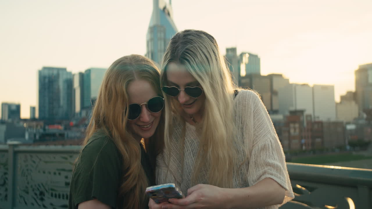 Two friends taking a selfie in front of a cityscape