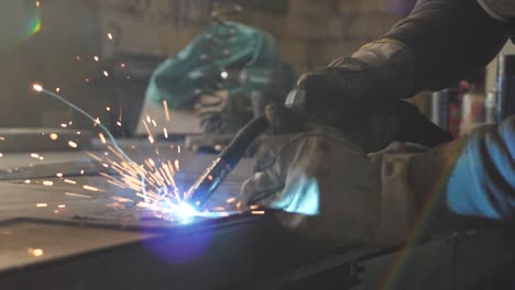 welder on the table welds a set of metal parts