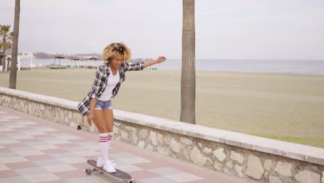 Junge-Frau-Beim-Skateboarden-An-Der-Strandpromenade