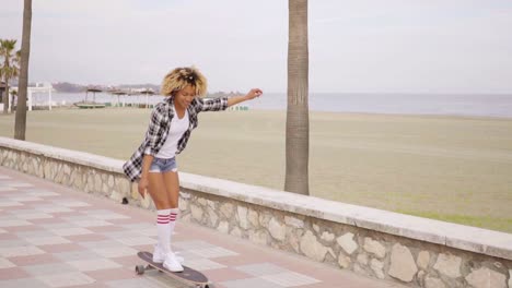 mujer joven patinando en el paseo marítimo