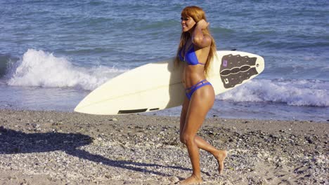 sexy joven musculosa surfista con su tabla