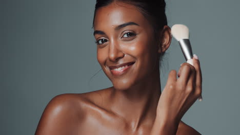 Beautiful woman applying makeup with a brush
