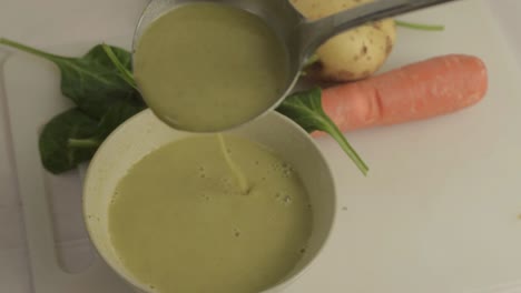 Pouring-healthy-vegetable-soup-into-a-bowl-with-ladle