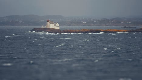 a lighthouse and lighthouse keeper's house stands on the solitary island near the kristiansand coast