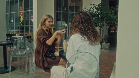 two women enjoying conversation in a cafe patio