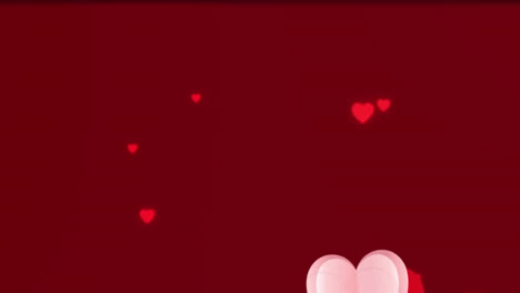 Animation-of-pink-heart-icons-floating-against-copy-space-on-red-background