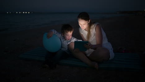 Mutter-Und-Sohn-Mit-Pad-Am-Meer-In-Der-Nacht