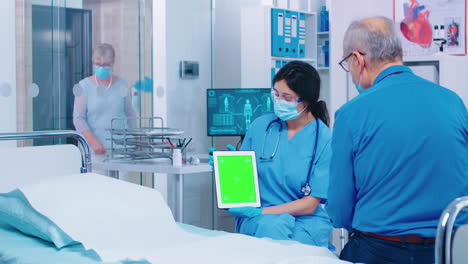 patient looking at green screen digital tablet