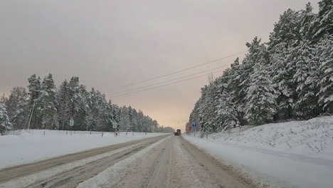 Driving-along-road-covered-in-snow---driver-point-of-view