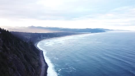 drone shot where the mountains meet the sea, flying along peaceful coastline