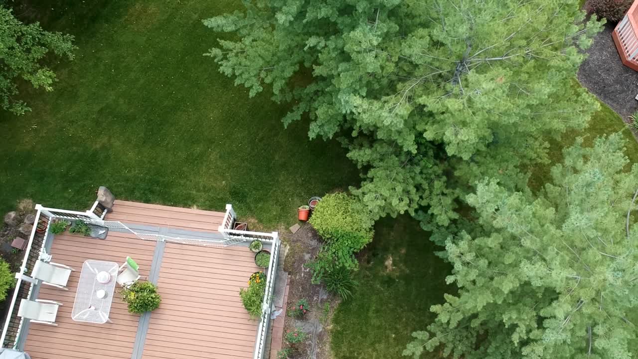 vista aérea casa patio trasero con silla, mesa y jardín