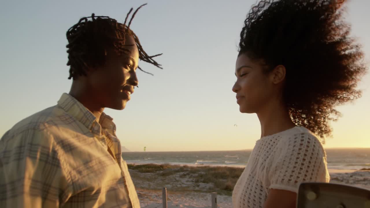 Couple talking with each other near pickup truck at beach 4k