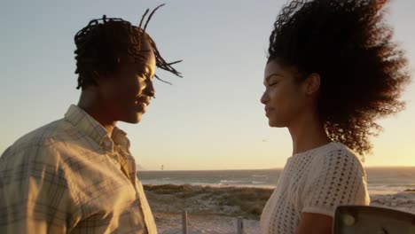 couple talking with each other near pickup truck at beach 4k