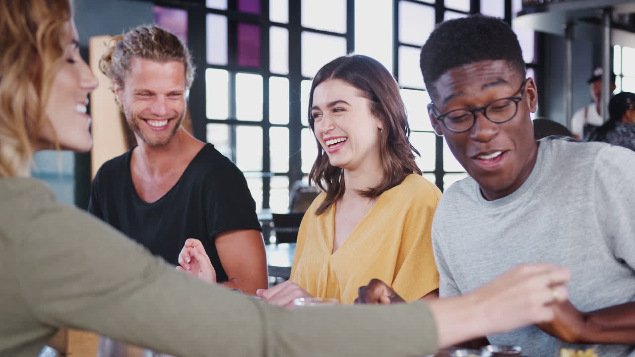 grupo de amigos reunidos para comer en un restaurante hablando
