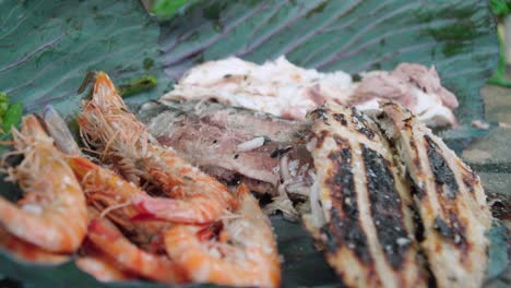 Drizzling-oil-and-salt-on-gourmet-assortment-of-grilled-fish-and-shrimp