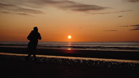 Mann-Läuft-Mit-Gitarre-Im-Hinteren-Sandstrand-Bei-Sonnenuntergang-3