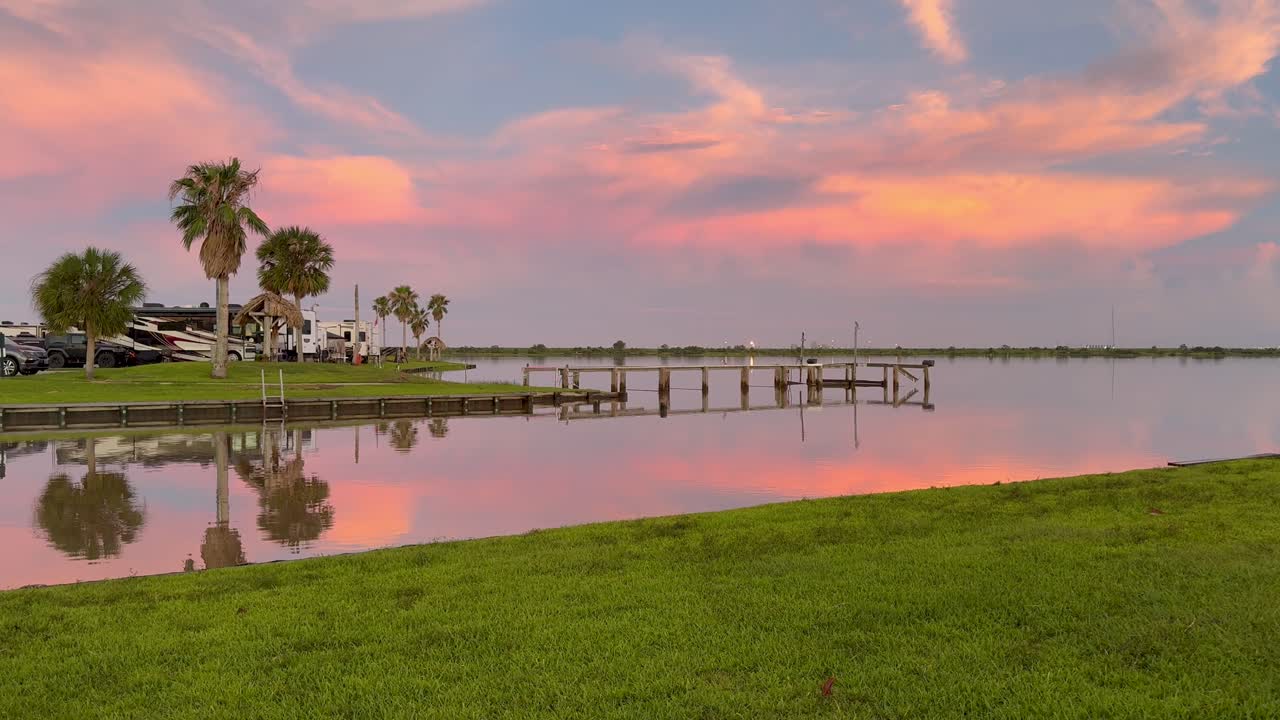 Colorful Sunset Reflection Over Water with Dock and Palm Trees at an RV Park
