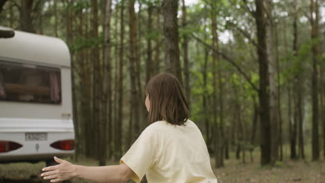 Loving-mother-crouching-while-her-happy-son-is-running-into-her-arms-at-the-camping-in-the-forest