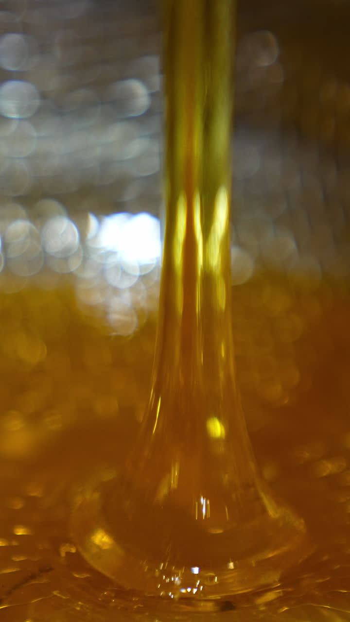Sweet golden honey pouring. Healthy organic food dripping in macro shot. Vertical video