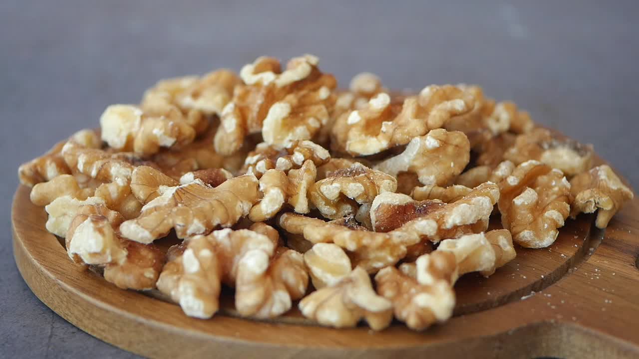 Close-up of a pile of walnuts on a wooden board
