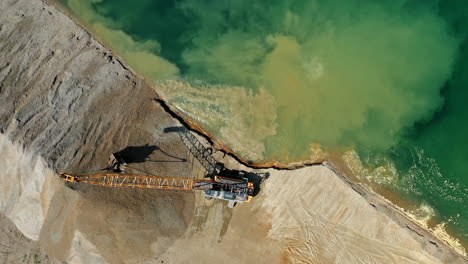 aerial top down view of an excavator loading crushed stone