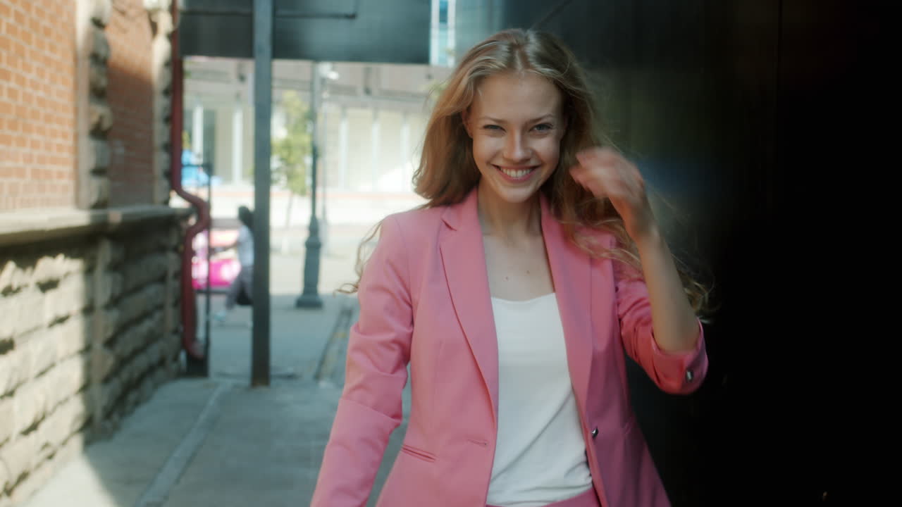 Stilfuld kvinde i en pink blazer i en bygyde
