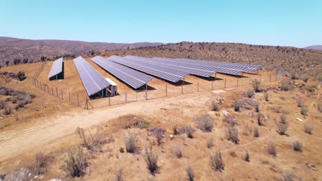 Low-aerial-dolly-shot-overhead-barren-landscape-and-a-small-solar-panel-field-in-Fray-Jorge