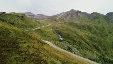 winding road along mountain ridge in austria captured in static aerial view