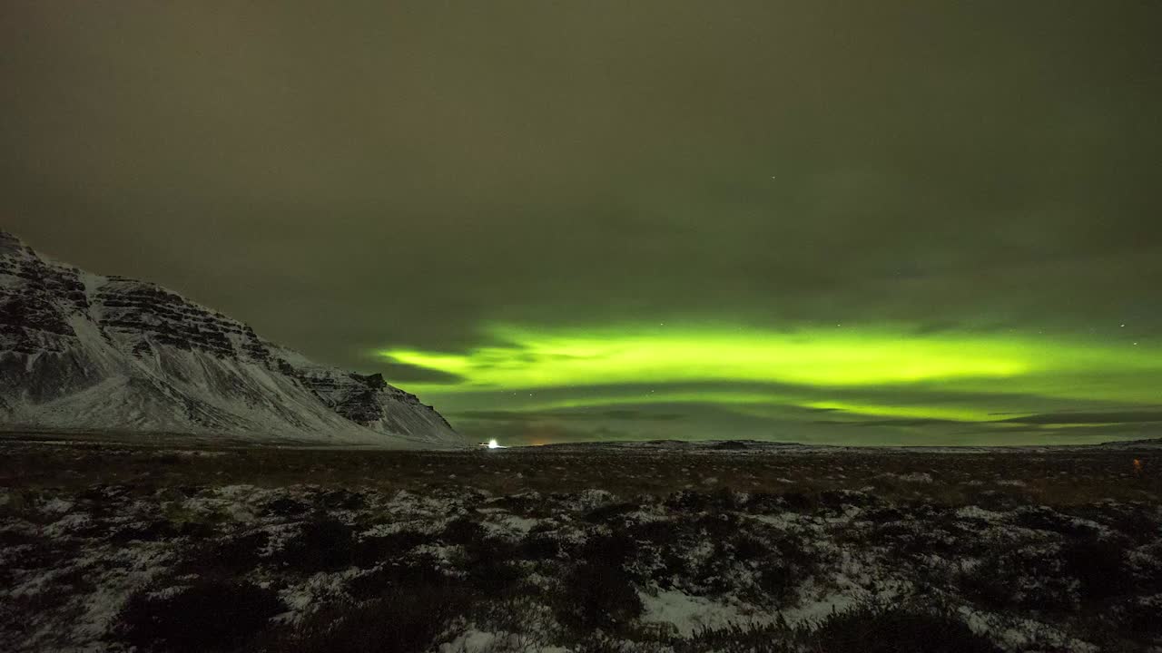el lapso de tiempo de las luces del norte sobre las montañas nevadas de islandia