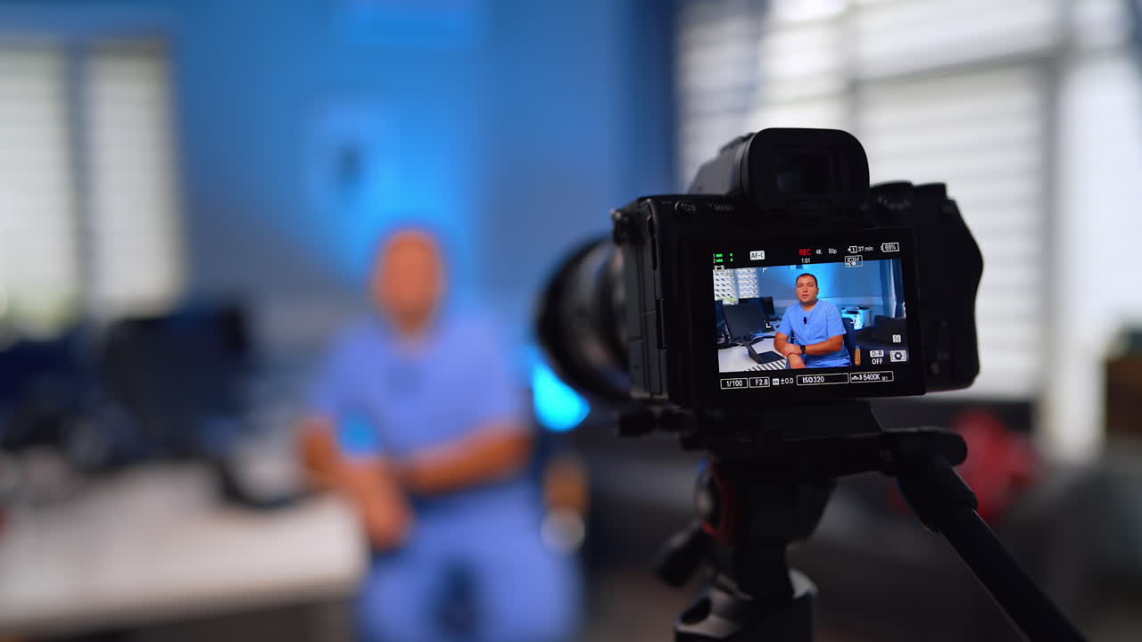 Professional digital camera display showing a doctor in blue uniform. Recording a video for medical vlog. Close up. Selective focus