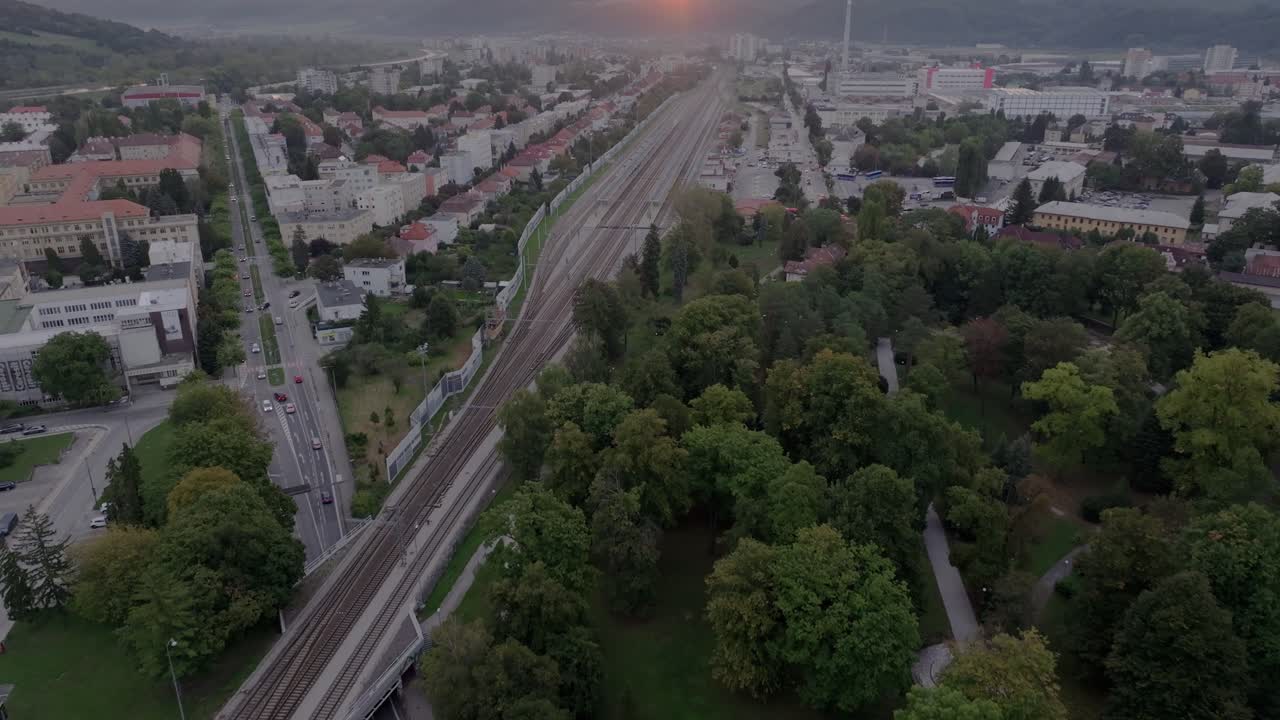 Съемка с дрона железнодорожных путей и городского пейзажа на рассвете, Тренчин.