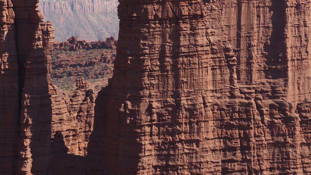 Fisher Towers vicino a Moab, Utah, che mostra imponenti formazioni rocciose rosse e un canyon aspro. Ripresa aerea in ascesa.