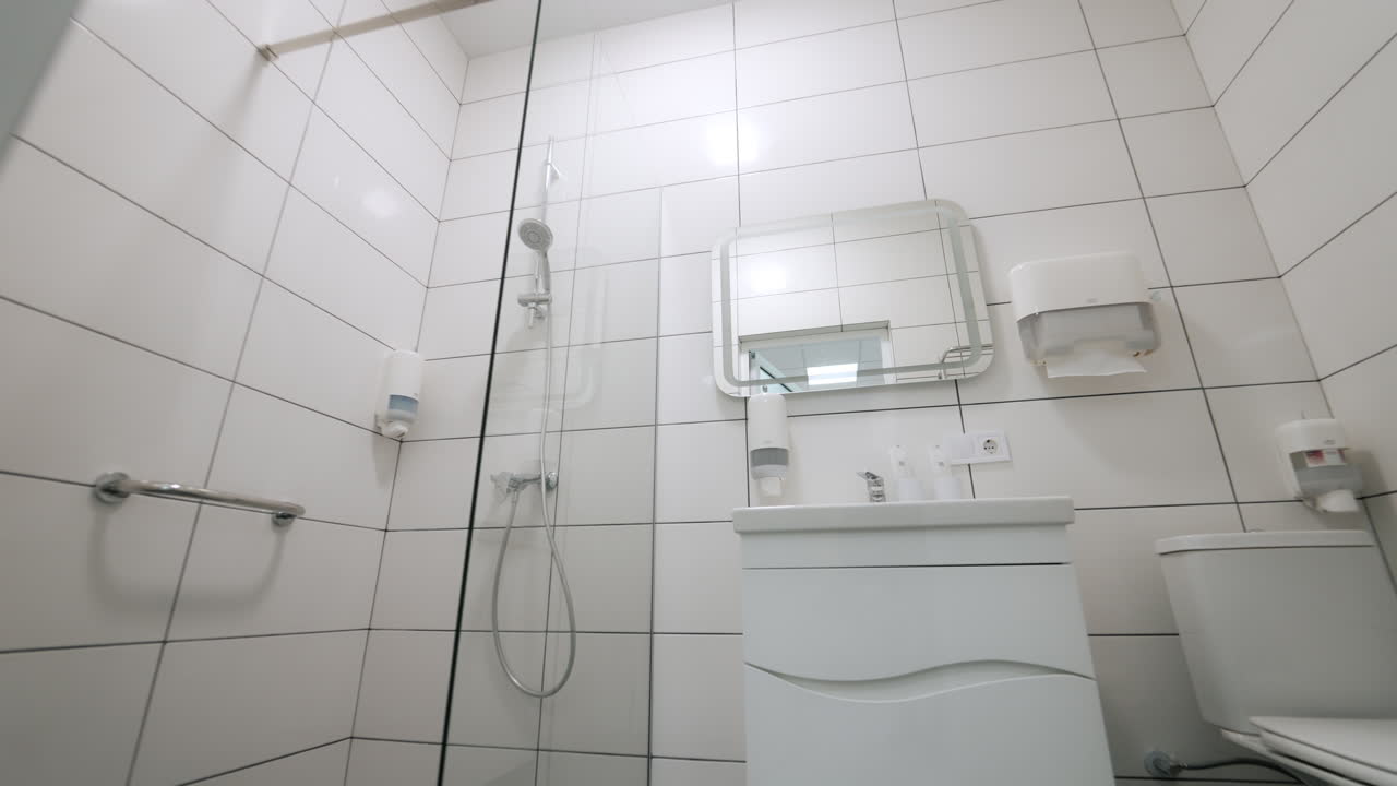 Kyiv, Ukraine, 3. august 2025: Sterilt badeværelseinteriør på et moderne medicinsk anlæg med bruser.